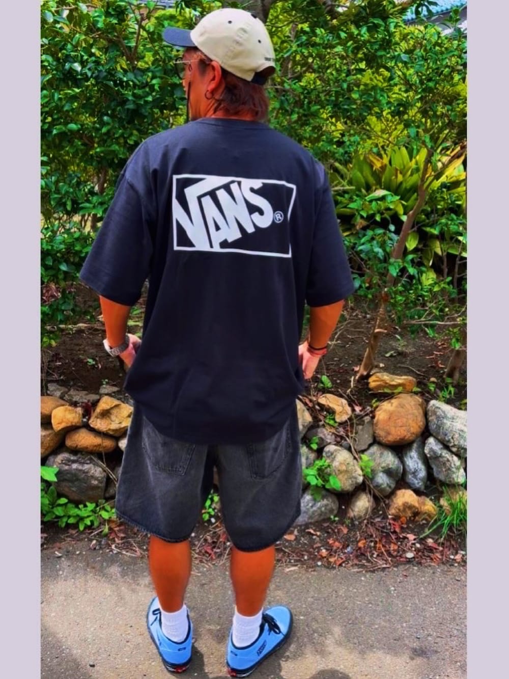 ブラック系のデニムパンツ、ブラック系のTシャツ/カットソー、ブルー系のスニーカーを着用したメンズの秋コーディネートの5枚目の写真