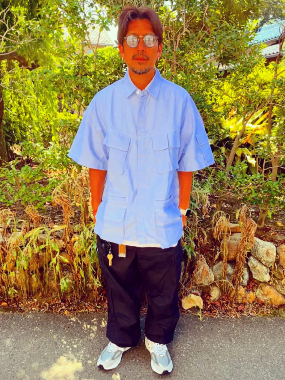 ブルー系のシャツ/ブラウス、ブラック系のカーゴパンツ、グレー系のスニーカーを着用したメンズの夏コーディネートの2枚目の写真