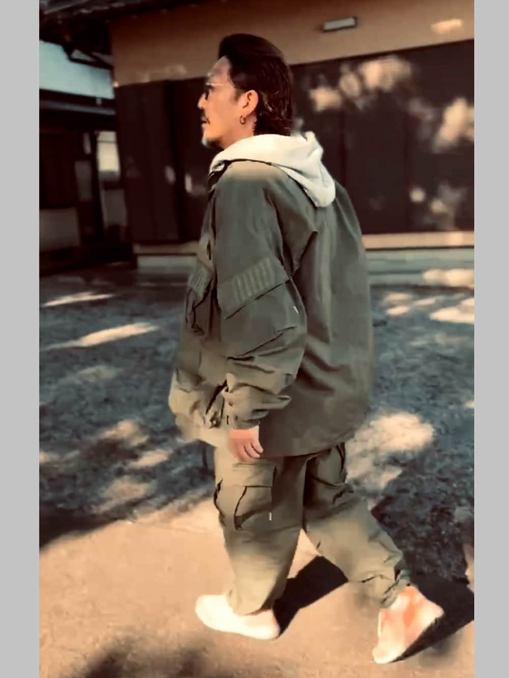 ブラック系のTシャツ/カットソー、グレー系のパーカー、グリーン系のミリタリージャケットを着用したメンズの冬コーディネートの2枚目の写真