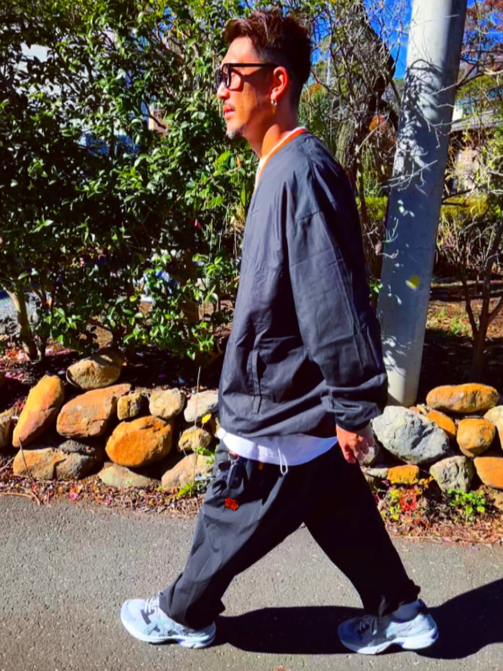 ブラック系のナイロンジャケット、ブラック系のその他パンツ、ホワイト系のスニーカーを着用したメンズの冬コーディネートの4枚目の写真