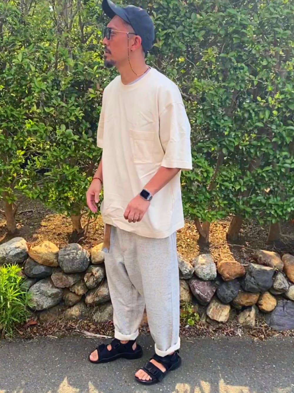 ブラック系のTシャツ/カットソー、シルバー系のスウェットパンツ、ブラック系のサンダルを着用したメンズの夏コーディネートの2枚目の写真