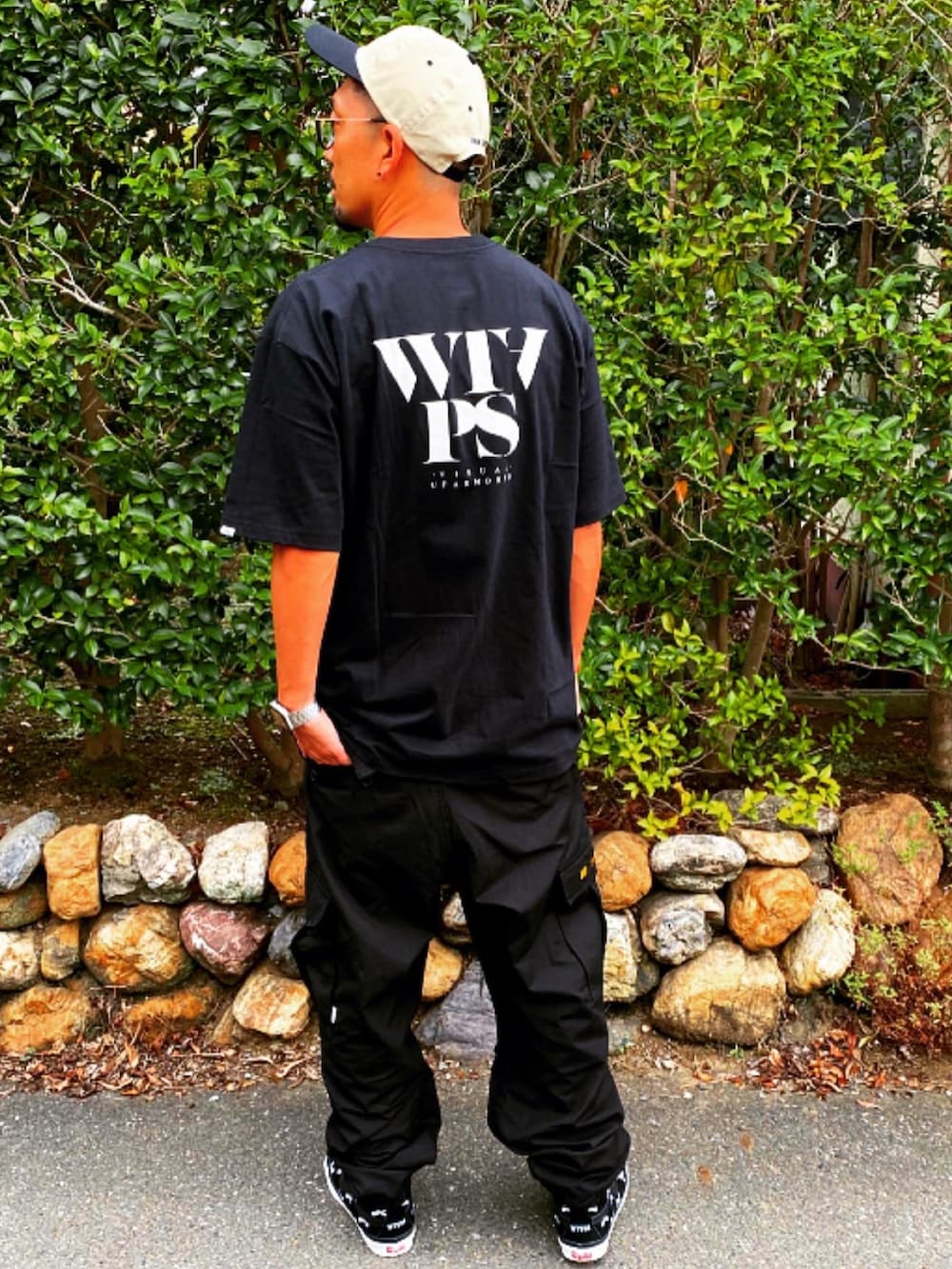 ブラック系のTシャツ/カットソー、ブラック系のカーゴパンツ、ブラック系のスニーカーを着用したメンズの夏コーディネートの5枚目の写真