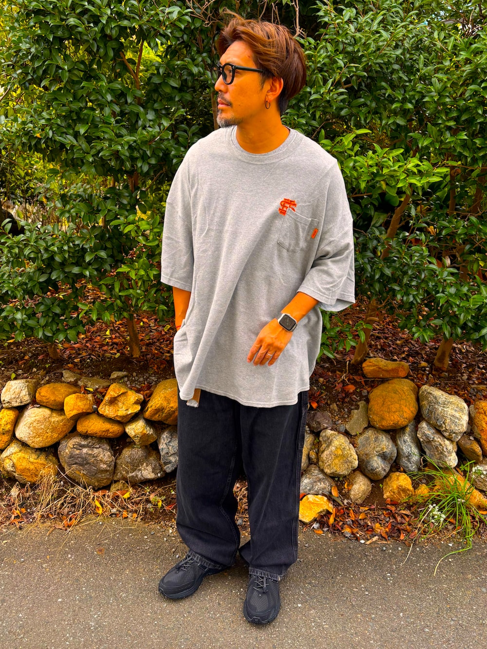 グレー系のTシャツ/カットソー、ブラック系のデニムパンツ、ブラック系のスニーカーを着用したメンズの秋コーディネートの4枚目の写真