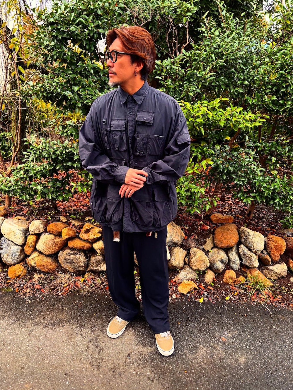 グレー系のTシャツ/カットソー、ベージュ系のスニーカー、ブラック系のミリタリージャケットを着用したメンズの秋コーディネートの2枚目の写真