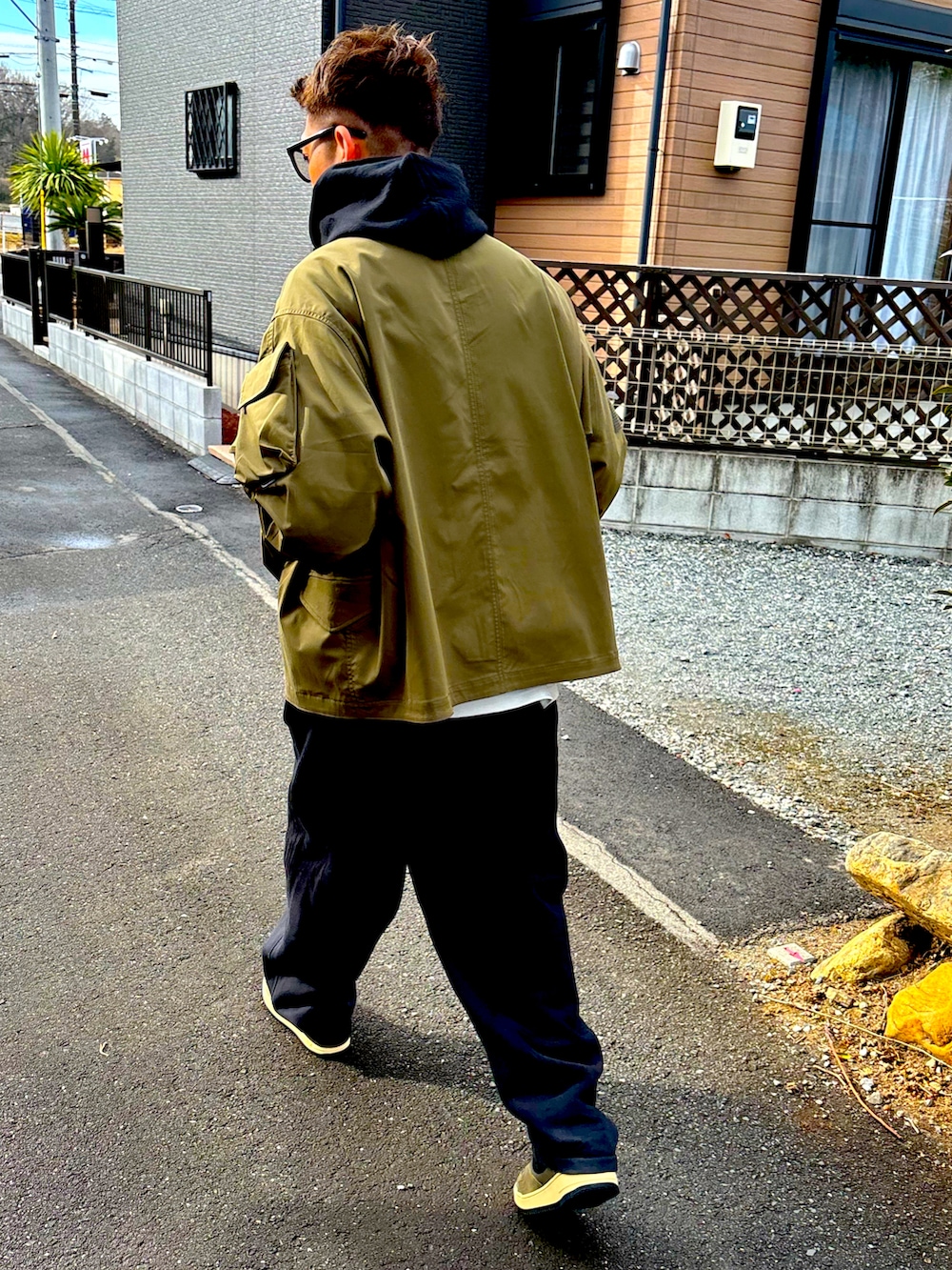 ブラック系のパーカー、グリーン系のミリタリージャケット、ベージュ系のスウェットパンツを着用したメンズの冬コーディネートの5枚目の写真