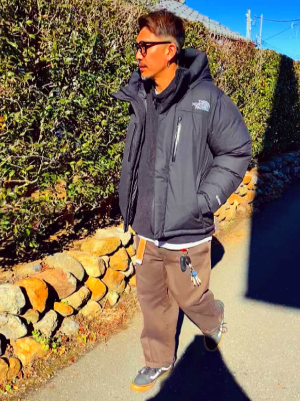 ブラック系のダウンジャケット/コート、ブラック系のナイロンジャケット、レッド系のチノパンツを着用したメンズの冬コーディネートの2枚目の写真