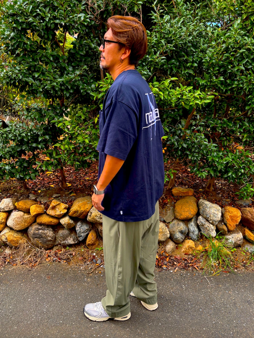 ブルー系のTシャツ/カットソー、グリーン系のその他パンツ、ブラック系のスニーカーを着用したメンズの秋コーディネートの2枚目の写真