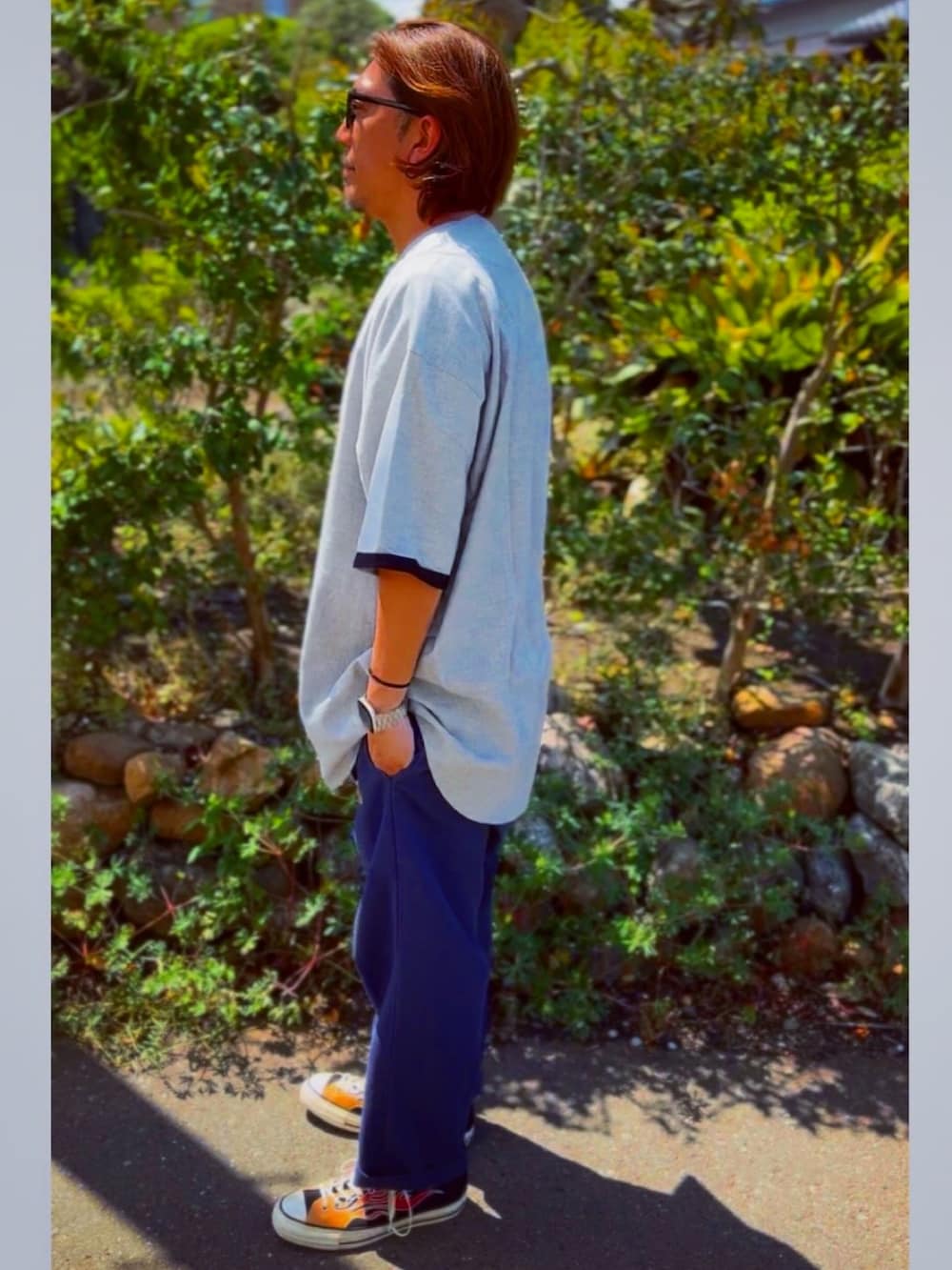 ブラック系のチノパンツ、グレー系のTシャツ/カットソー、その他のスニーカーを着用したメンズの春コーディネートの4枚目の写真