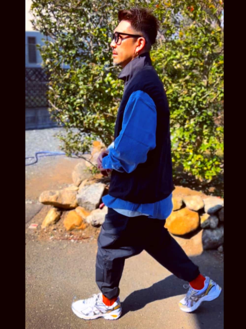 ブラック系のダウンベスト、ブルー系のシャツ/ブラウス、ブラック系のその他パンツを着用したメンズの春コーディネートの4枚目の写真