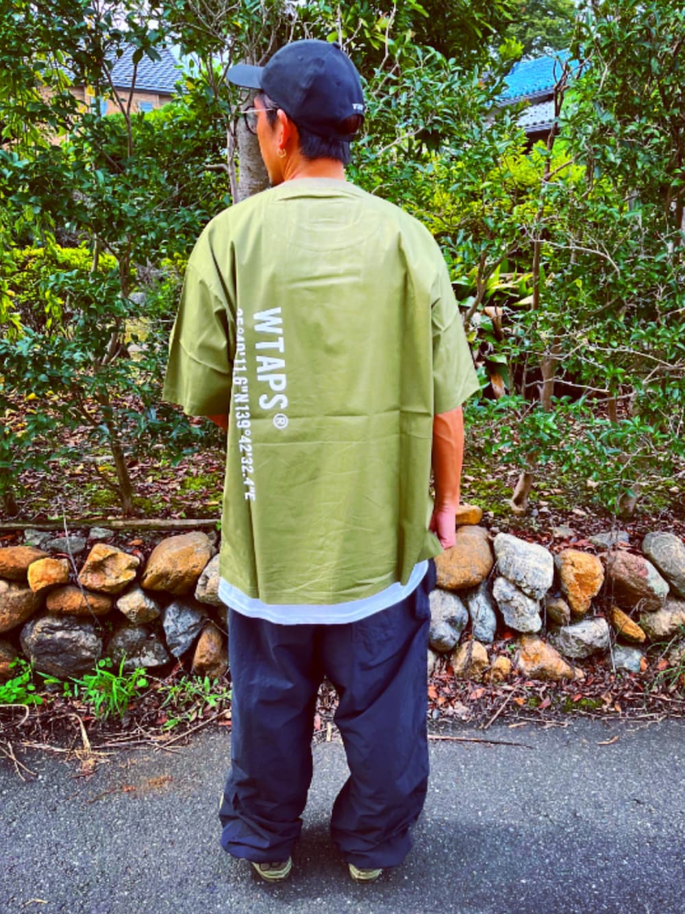 グリーン系のTシャツ/カットソー、ブラック系のその他パンツ、グリーン系のスニーカーを着用したメンズの秋コーディネートの5枚目の写真