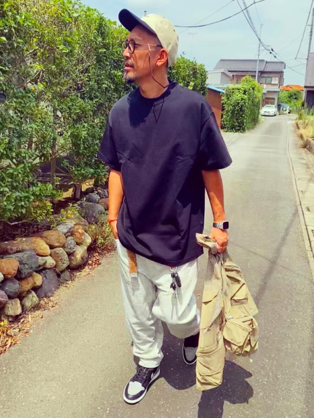 ブラック系のTシャツ/カットソー、シルバー系のスウェットパンツ、グレー系のスニーカーを着用したメンズの夏コーディネートの5枚目の写真