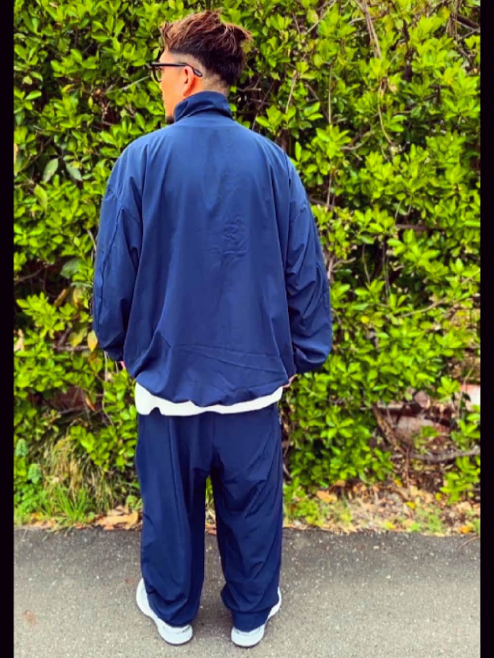 ブルー系のナイロンジャケット、ブルー系のその他パンツ、グレー系のスニーカーを着用したメンズの春コーディネートの4枚目の写真