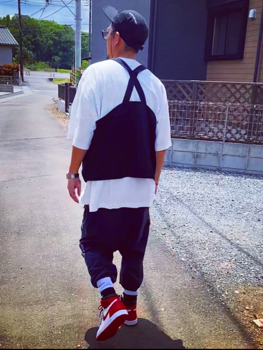 ブラック系のベスト、ホワイト系のTシャツ/カットソー、ブラック系のカーゴパンツを着用したメンズの春コーディネートの5枚目の写真