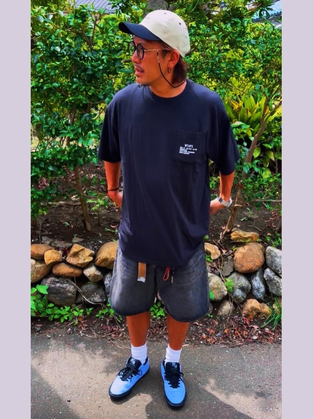 ブラック系のデニムパンツ、ブラック系のTシャツ/カットソー、ブルー系のスニーカーを着用したメンズの秋コーディネートの3枚目の写真