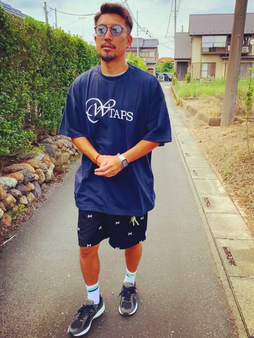 ブラック系のその他パンツ、ブルー系のTシャツ/カットソー、ブラック系のスニーカーを着用したメンズの夏コーディネートの3枚目の写真