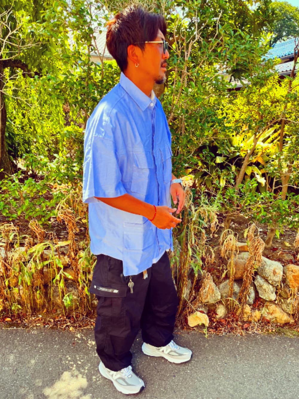 ブルー系のシャツ/ブラウス、ブラック系のカーゴパンツ、グレー系のスニーカーを着用したメンズの夏コーディネートの3枚目の写真