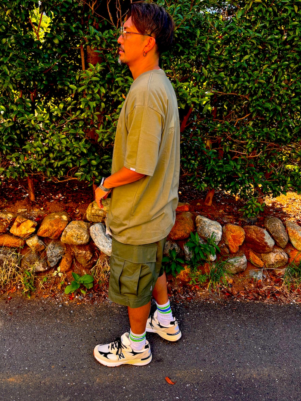 グリーン系のTシャツ/カットソー、グリーン系のその他パンツ、ホワイト系のスニーカーを着用したメンズの夏コーディネートの3枚目の写真