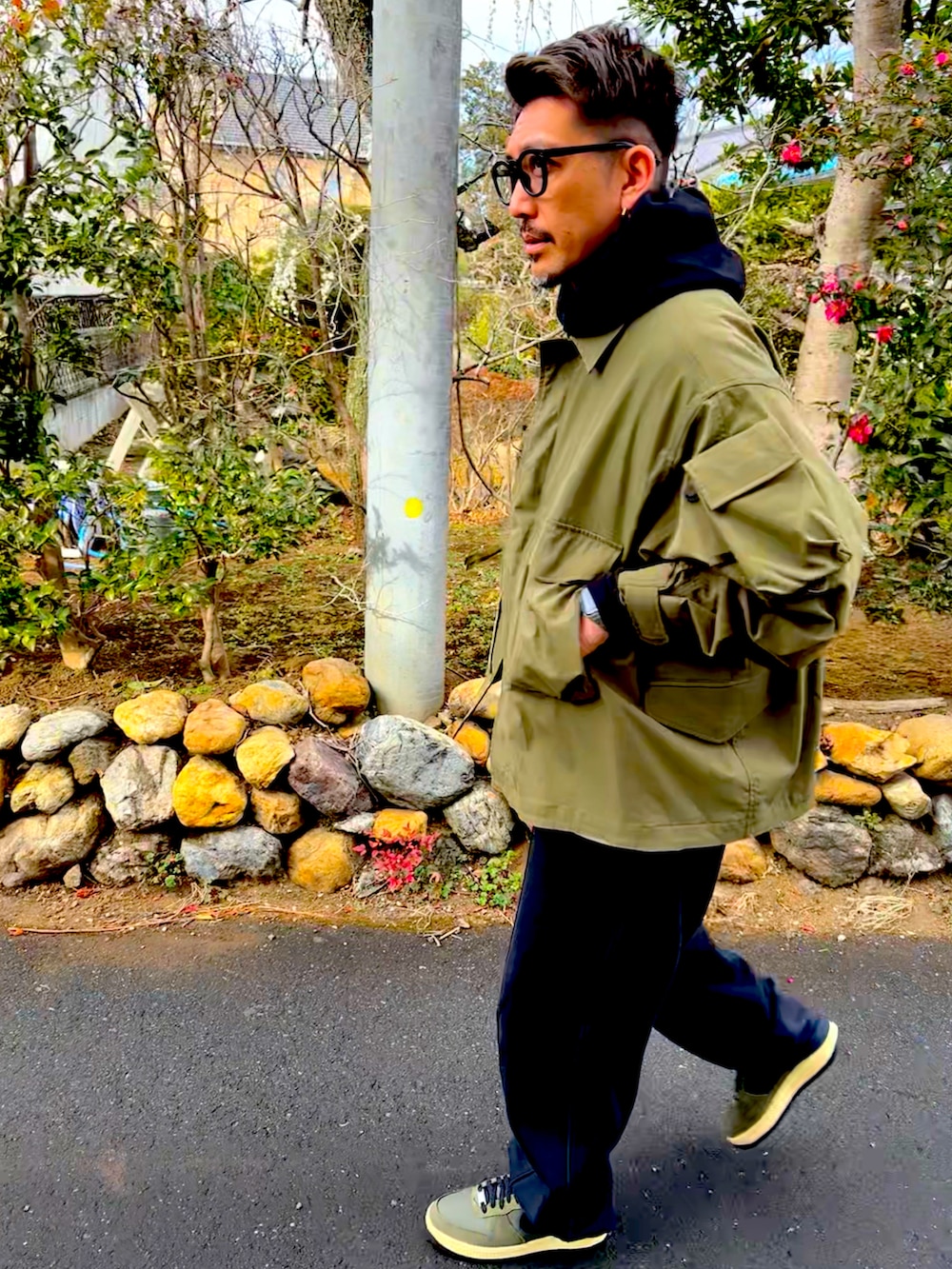 ブラック系のパーカー、グリーン系のミリタリージャケット、ベージュ系のスウェットパンツを着用したメンズの冬コーディネートの3枚目の写真