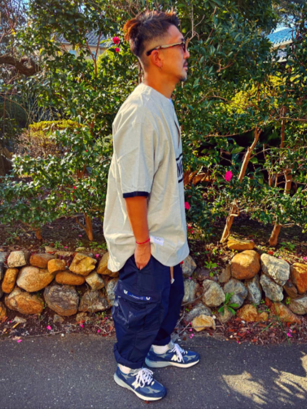 グレー系のTシャツ/カットソー、ブルー系のカーゴパンツ、ブルー系のスニーカーを着用したメンズの秋コーディネートの5枚目の写真