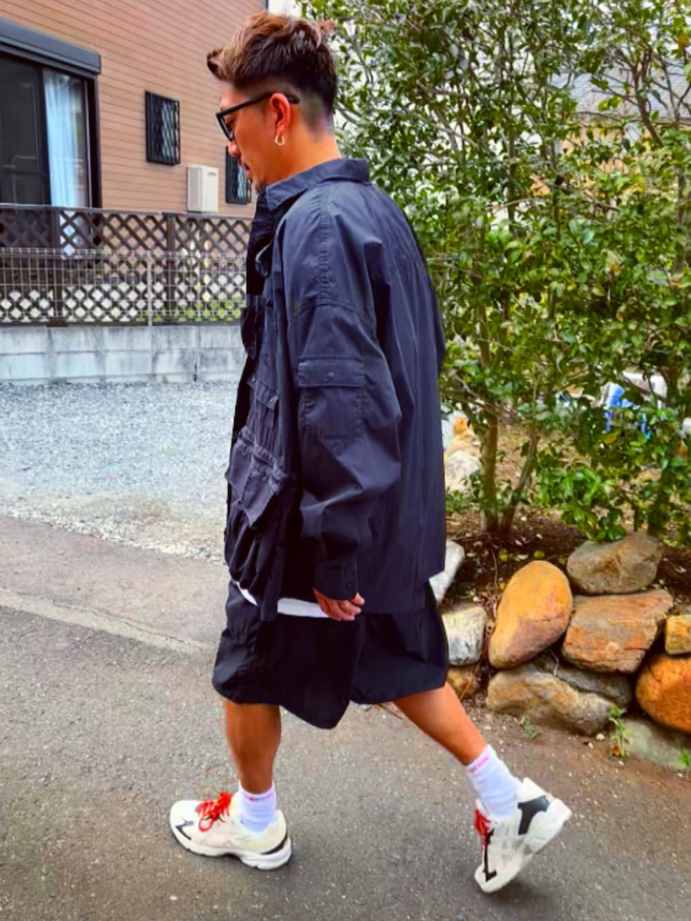 ブラック系のミリタリージャケット、ブラック系のTシャツ/カットソー、ブラック系のカーゴパンツを着用したメンズの春コーディネートの5枚目の写真