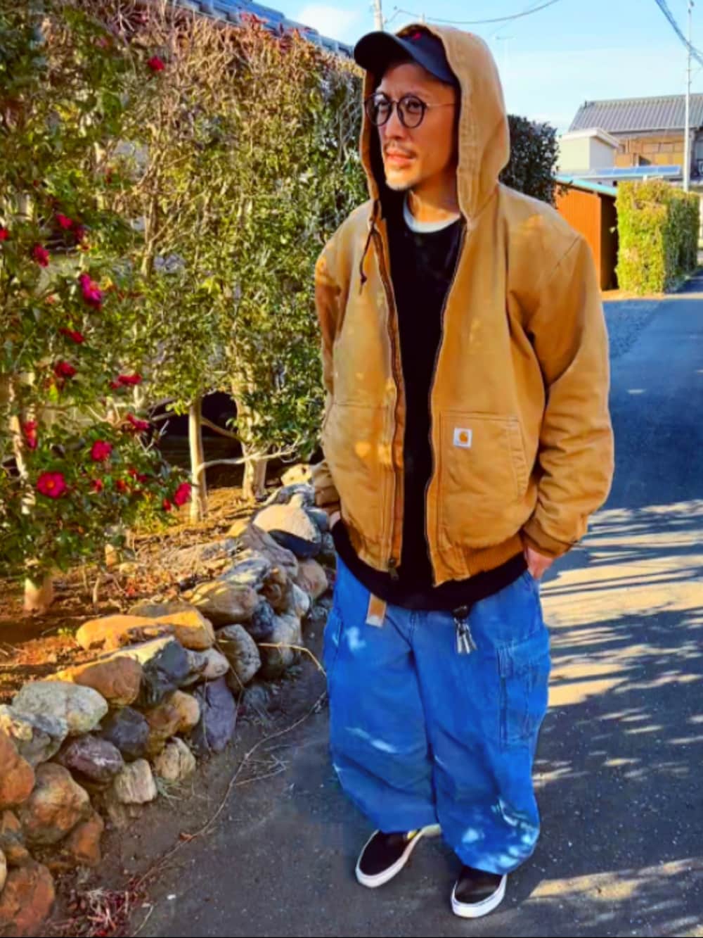 ブラウン系のブルゾン、ブラック系のTシャツ/カットソー、ブルー系のカーゴパンツを着用したメンズの冬コーディネートの3枚目の写真