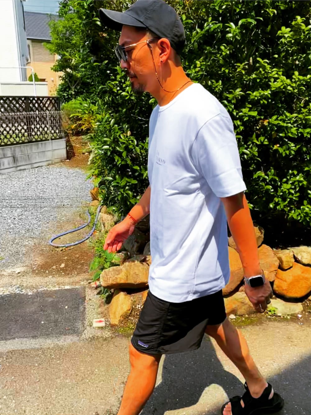 ホワイト系のTシャツ/カットソー、ブラック系のその他パンツ、ブラック系のサンダルを着用したメンズの夏コーディネートの5枚目の写真