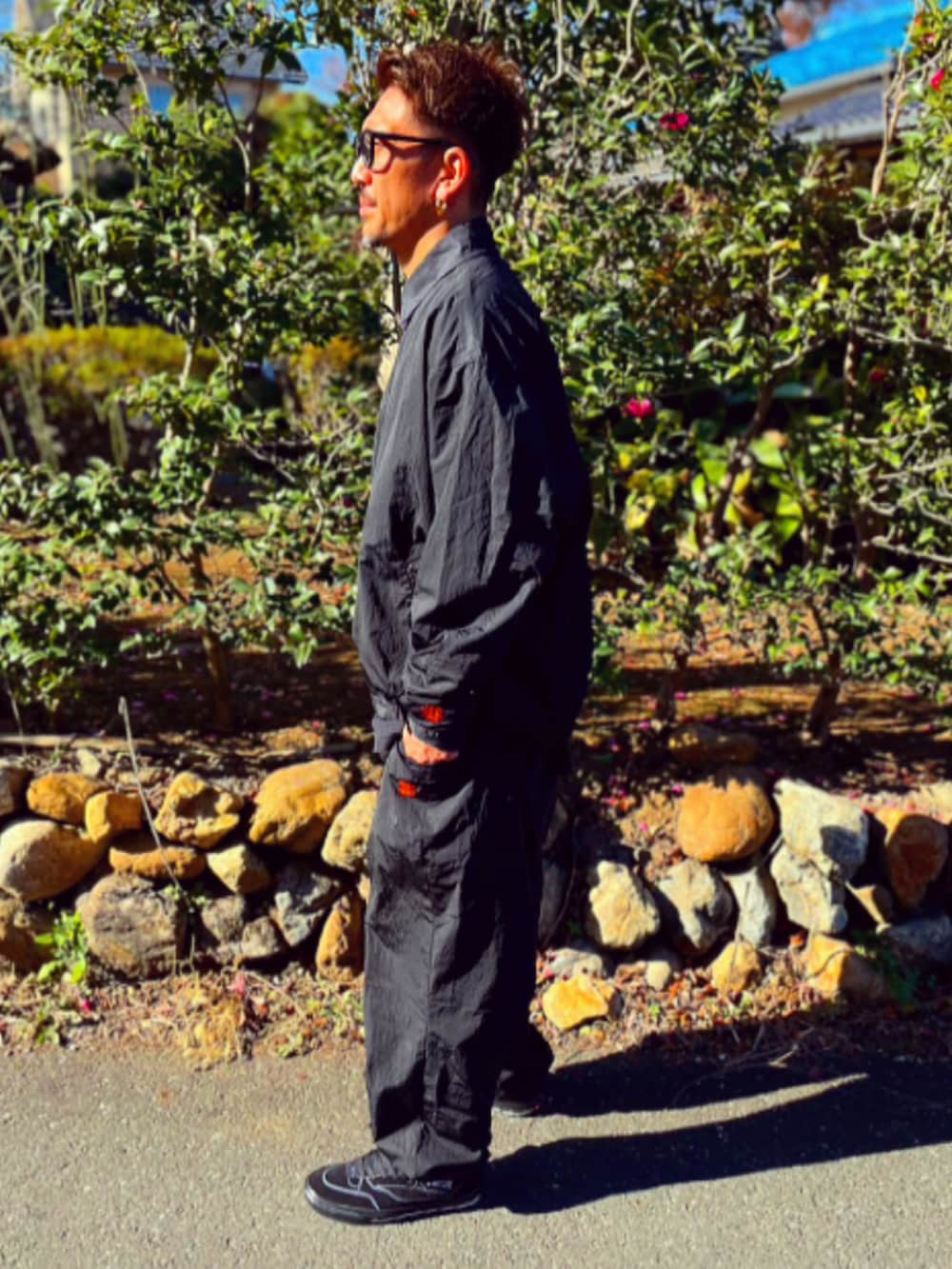 ブラック系のナイロンジャケット、ブラック系のその他パンツ、ブラック系のスニーカーを着用したメンズの冬コーディネートの4枚目の写真