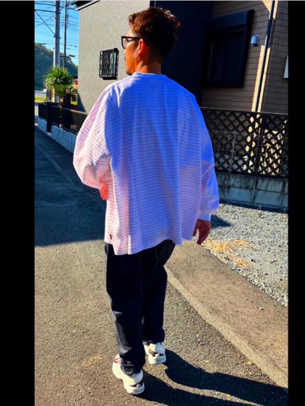 ホワイト系のTシャツ/カットソー、ブルー系のその他パンツ、ホワイト系のスニーカーを着用したメンズの秋コーディネートの5枚目の写真