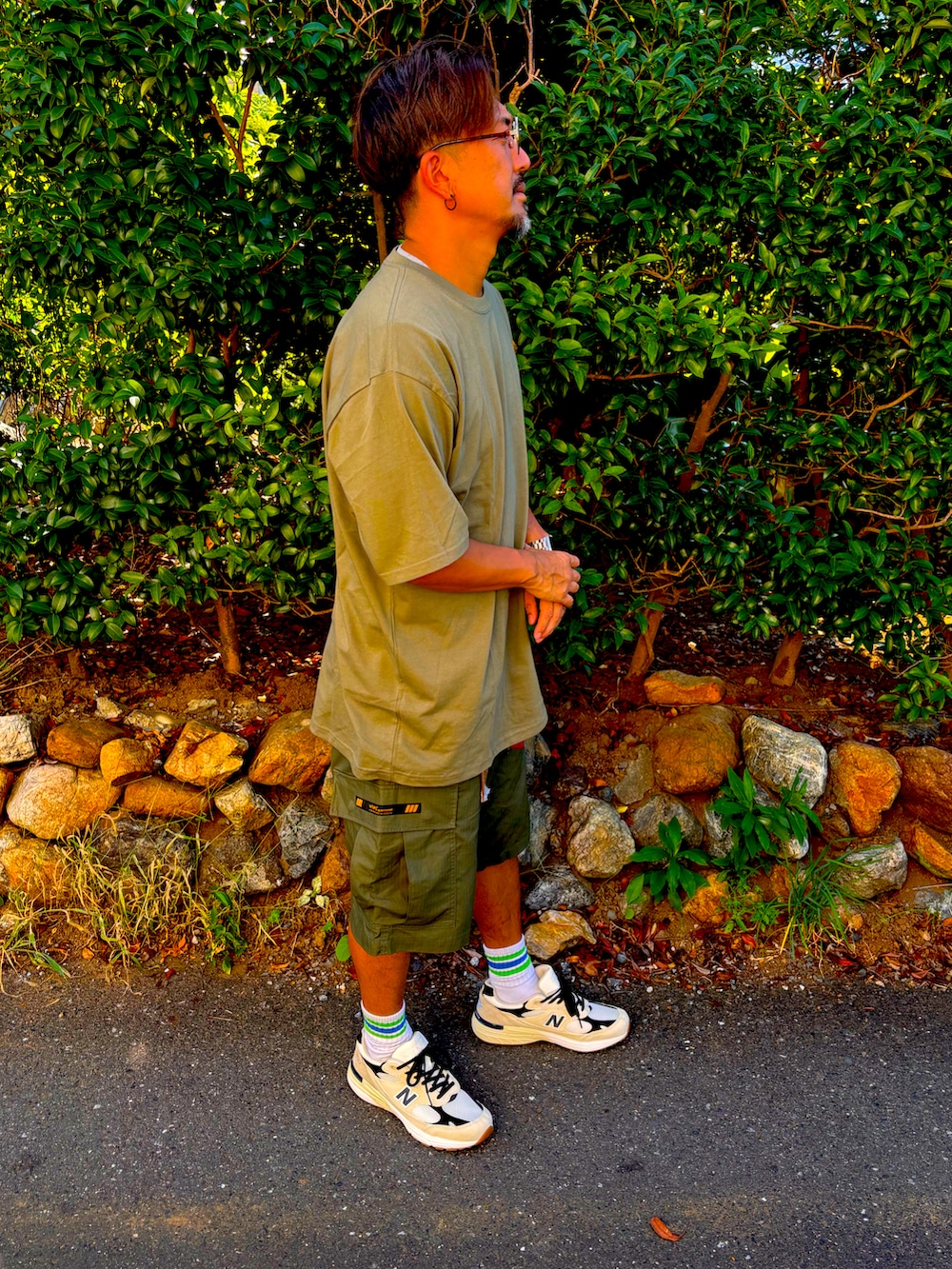 グリーン系のTシャツ/カットソー、グリーン系のその他パンツ、ホワイト系のスニーカーを着用したメンズの夏コーディネートの5枚目の写真