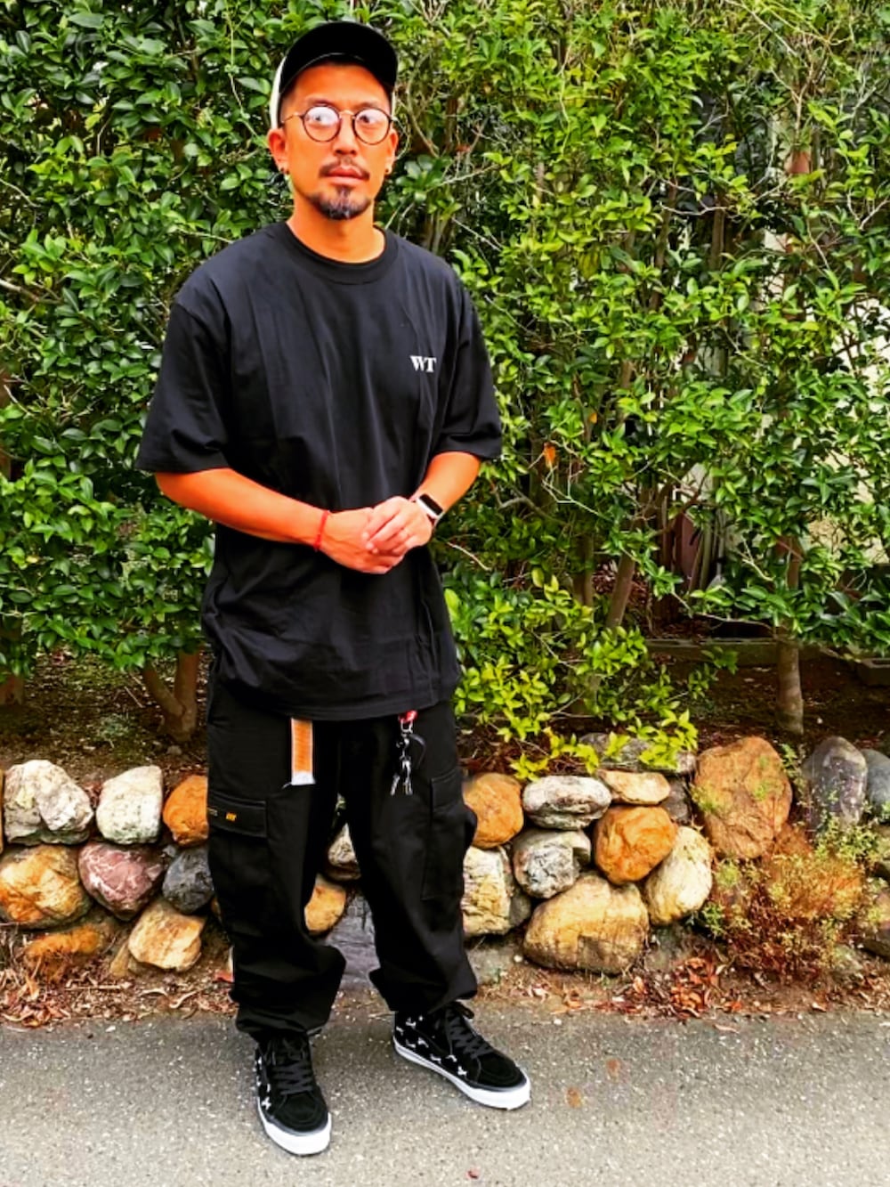 ブラック系のTシャツ/カットソー、ブラック系のカーゴパンツ、ブラック系のスニーカーを着用したメンズの夏コーディネートの2枚目の写真