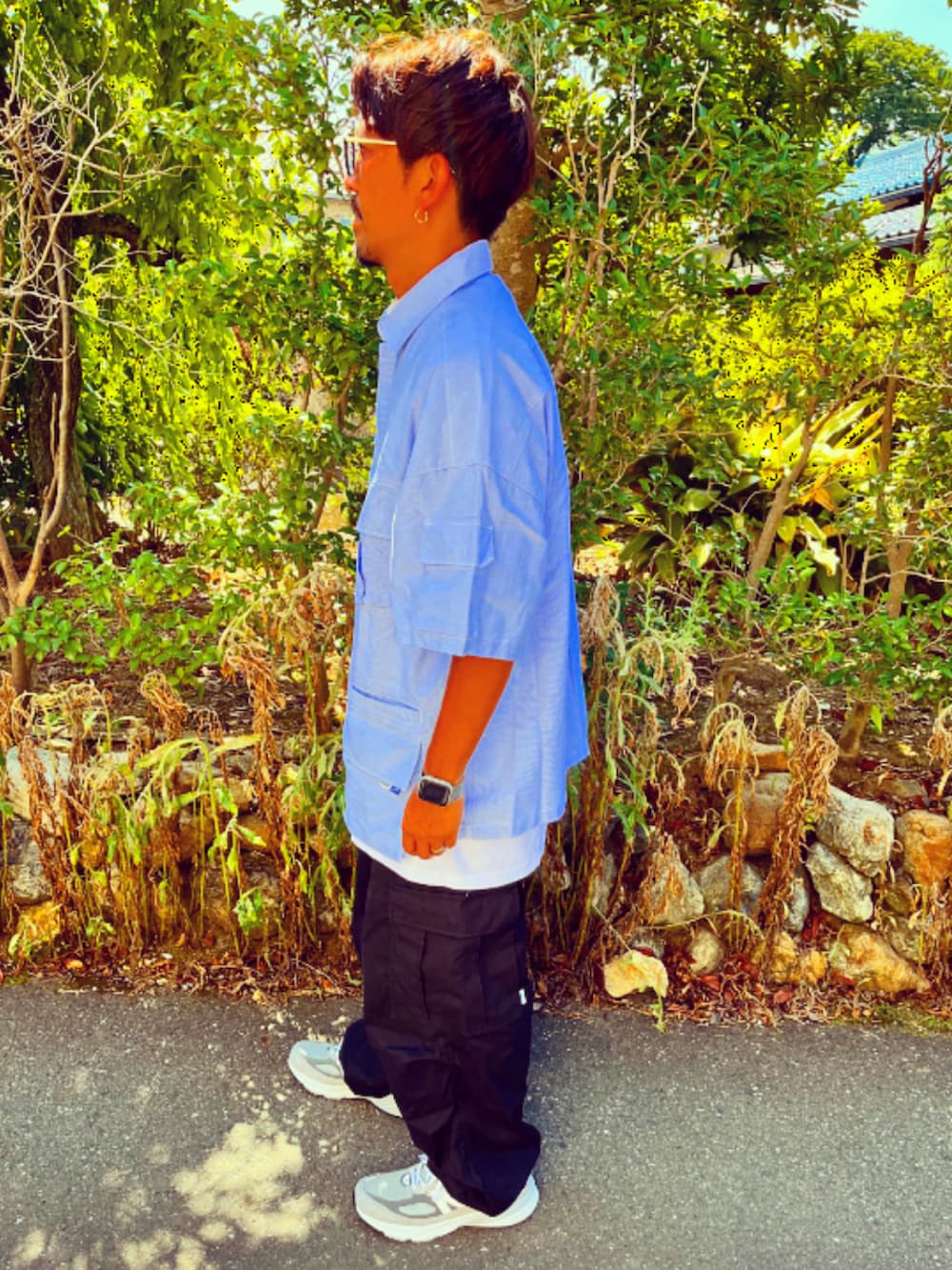 ブルー系のシャツ/ブラウス、ブラック系のカーゴパンツ、グレー系のスニーカーを着用したメンズの夏コーディネートの4枚目の写真