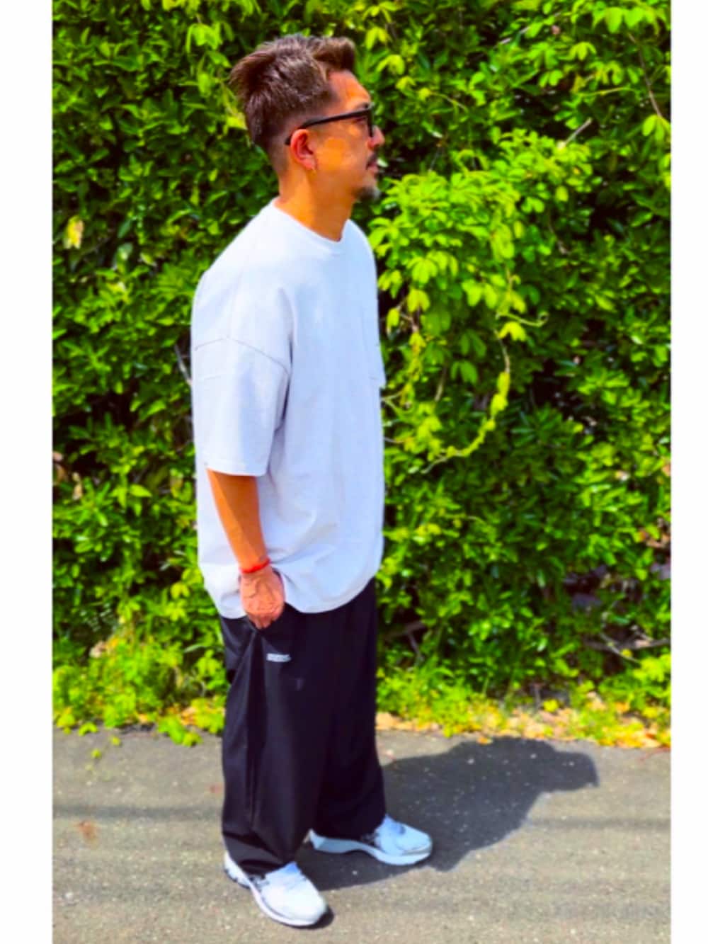 グレー系のTシャツ/カットソー、ブラック系のその他パンツ、ホワイト系のスニーカーを着用したメンズの春コーディネートの3枚目の写真