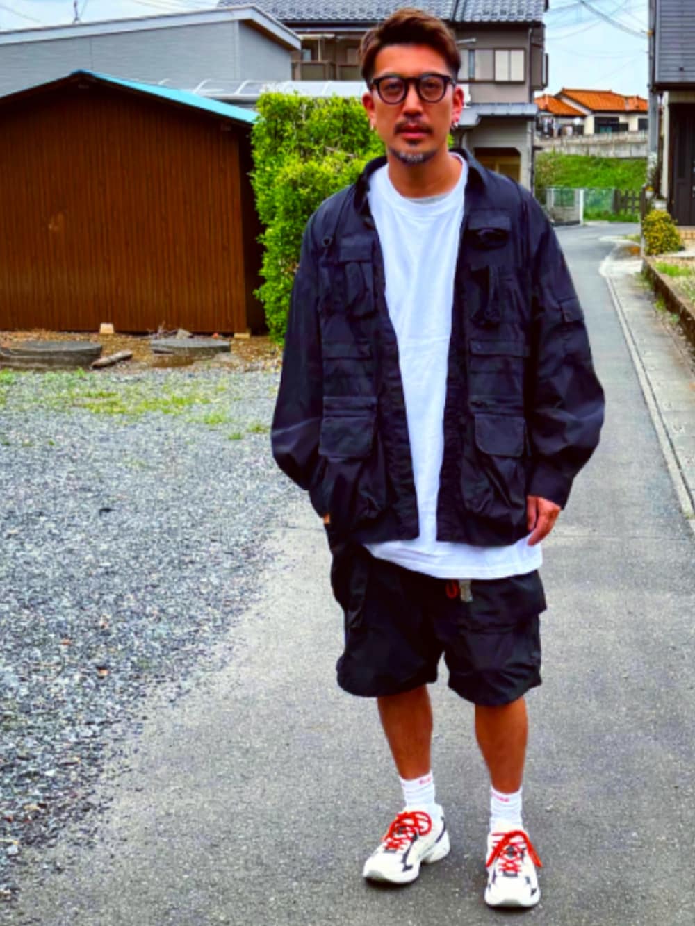 ブラック系のミリタリージャケット、ブラック系のTシャツ/カットソー、ブラック系のカーゴパンツを着用したメンズの春コーディネートの2枚目の写真