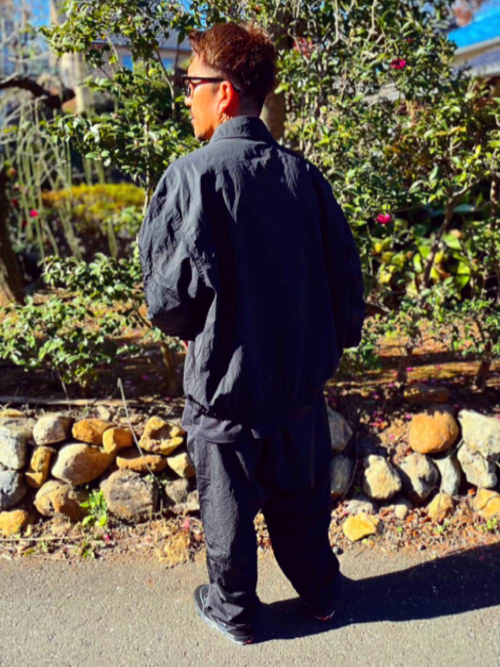 ブラック系のナイロンジャケット、ブラック系のその他パンツ、ブラック系のスニーカーを着用したメンズの冬コーディネートの5枚目の写真