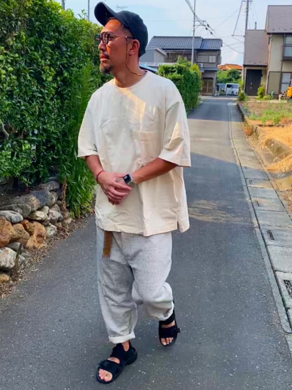 ブラック系のTシャツ/カットソー、シルバー系のスウェットパンツ、ブラック系のサンダルを着用したメンズの夏コーディネートの4枚目の写真