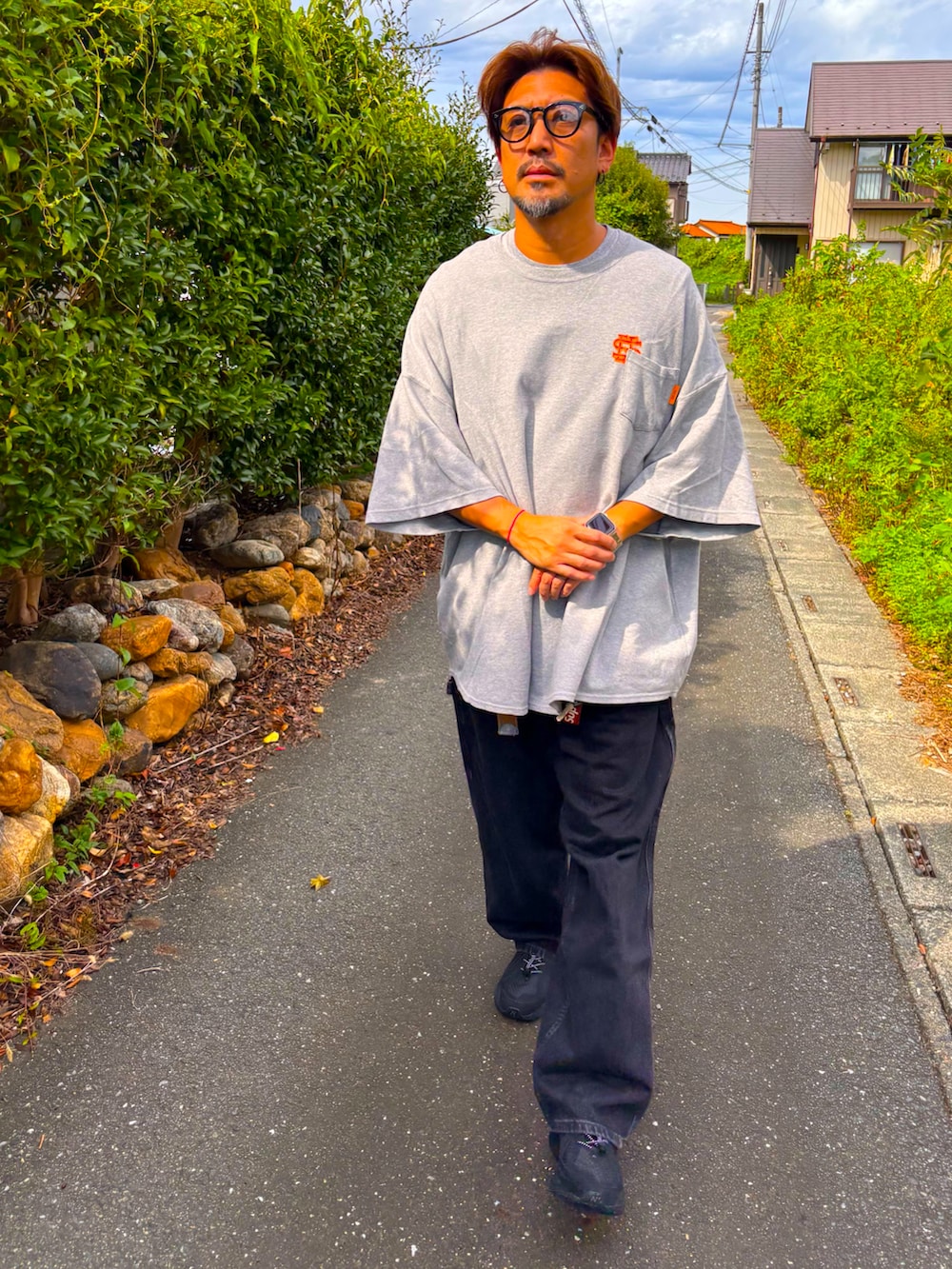 グレー系のTシャツ/カットソー、ブラック系のデニムパンツ、ブラック系のスニーカーを着用したメンズの秋コーディネートの2枚目の写真