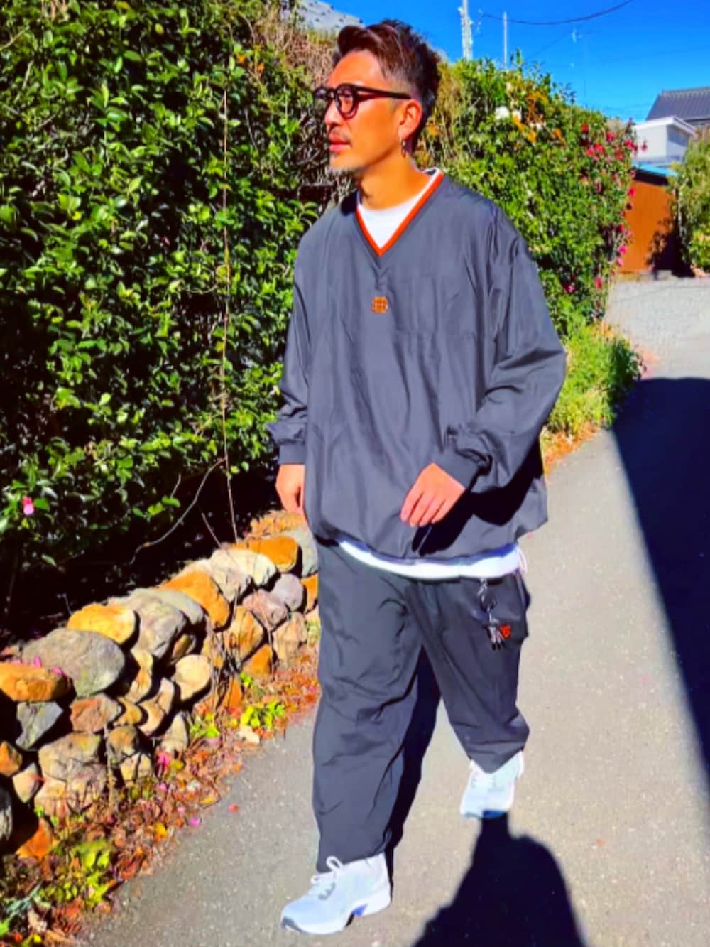 ブラック系のナイロンジャケット、ブラック系のその他パンツ、ホワイト系のスニーカーを着用したメンズの冬コーディネートの2枚目の写真