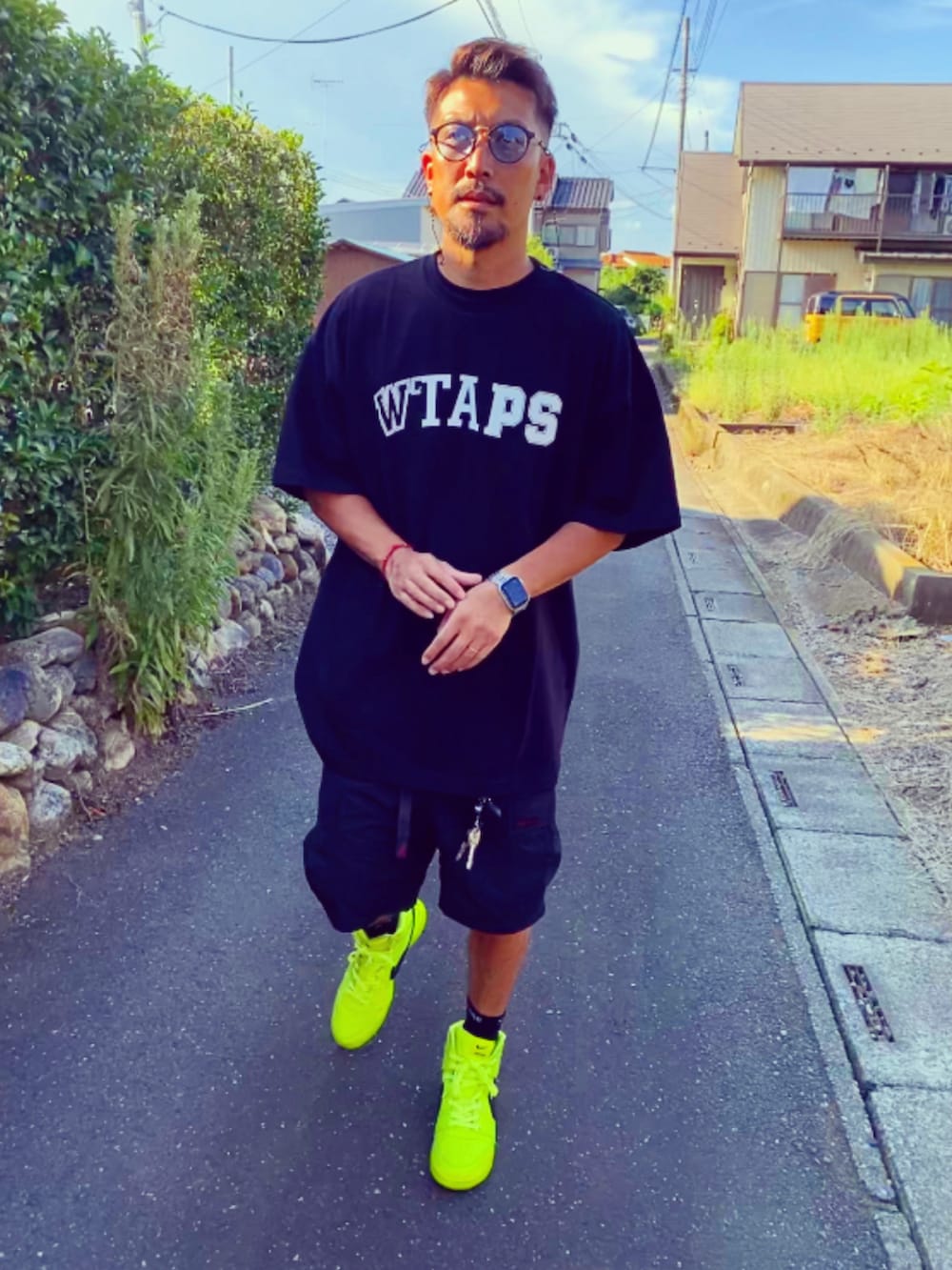 ブラック系のTシャツ/カットソー、ブラック系のカーゴパンツ、イエロー系のスニーカーを着用したメンズの夏コーディネートの3枚目の写真