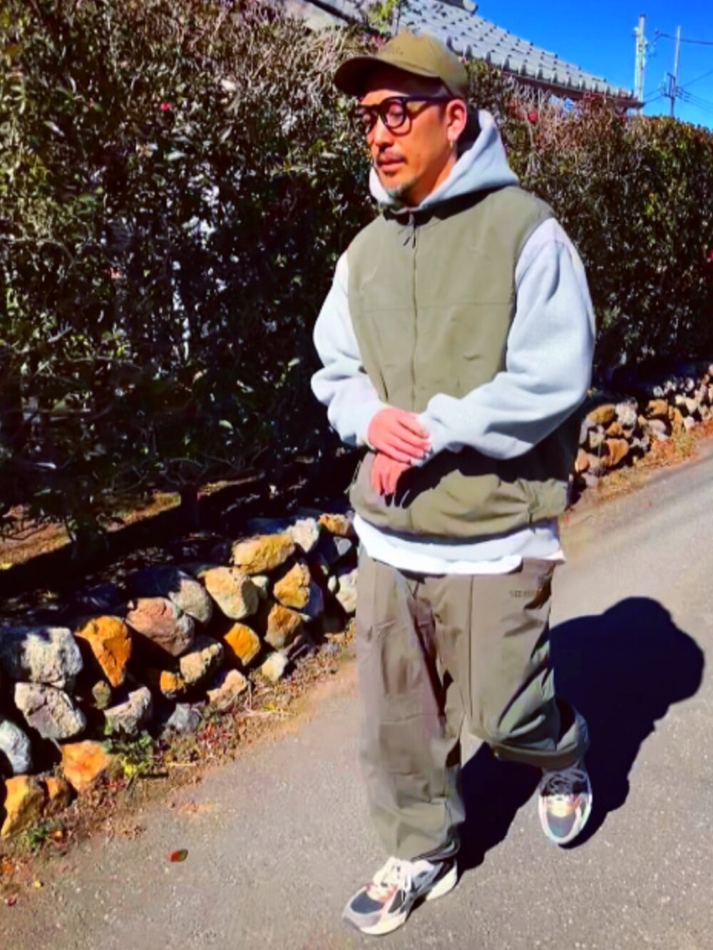 グリーン系のダウンベスト、グレー系のパーカー、グリーン系のその他パンツを着用したメンズの冬コーディネートの4枚目の写真