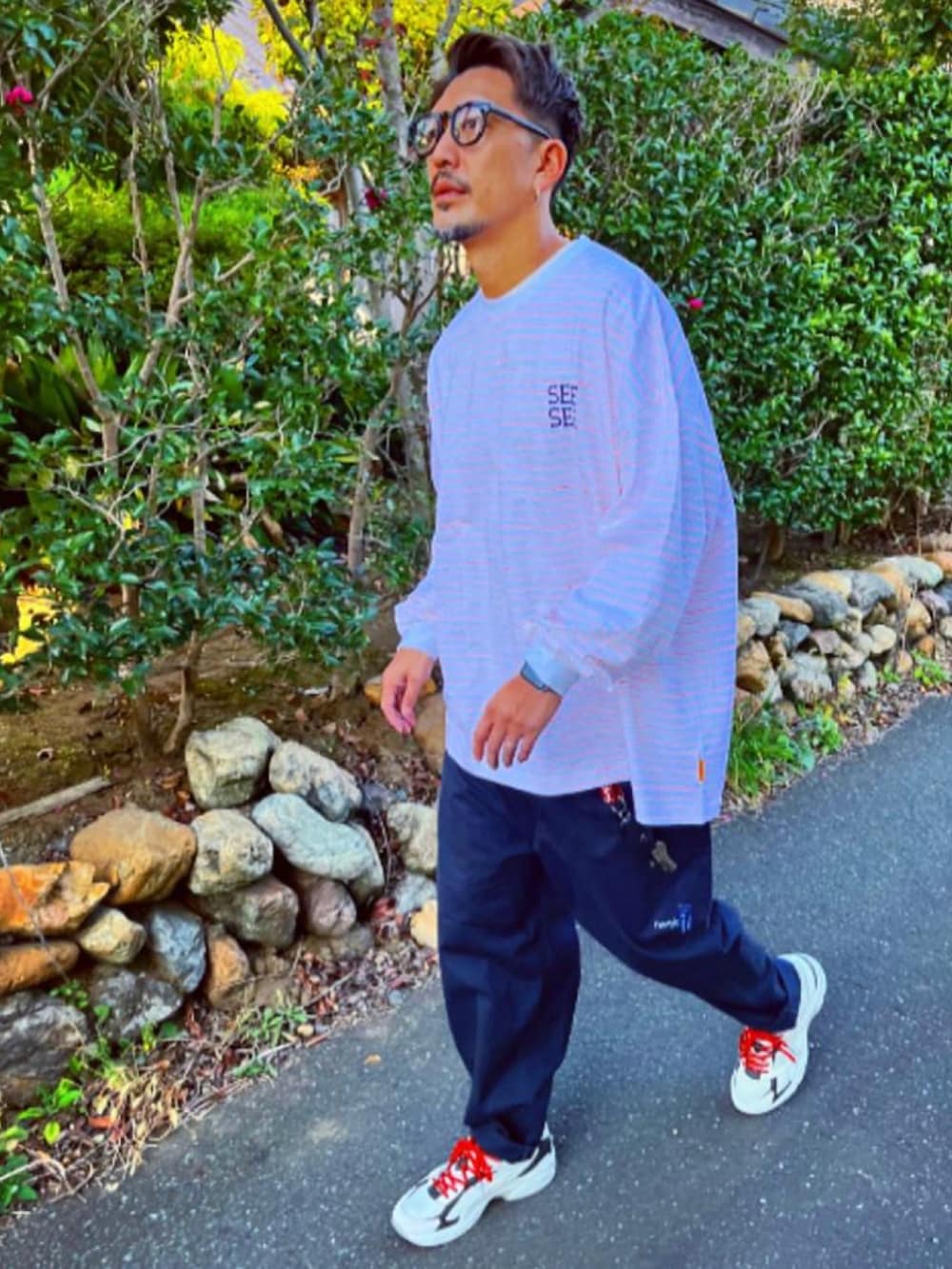 ホワイト系のTシャツ/カットソー、ブルー系のその他パンツ、ホワイト系のスニーカーを着用したメンズの秋コーディネートの3枚目の写真