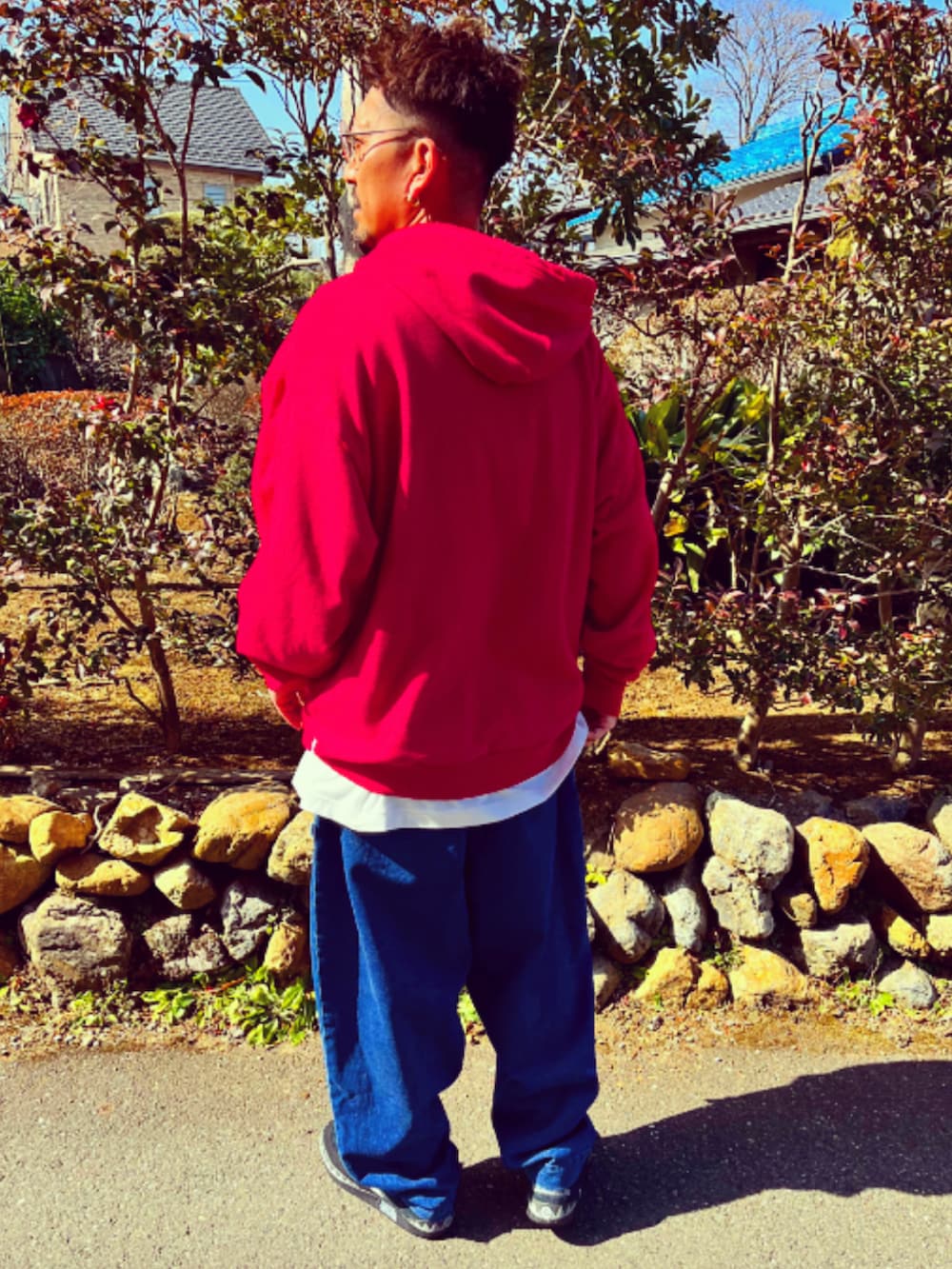 レッド系のパーカー、ホワイト系のTシャツ/カットソー、ブルー系のデニムパンツを着用したメンズの冬コーディネートの5枚目の写真