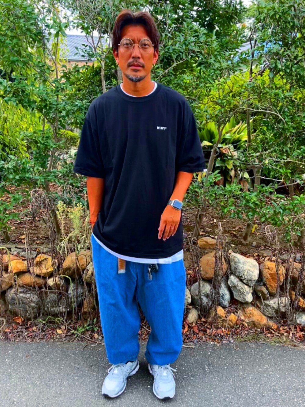 ブラック系のTシャツ/カットソー、ブルー系のデニムパンツ、グレー系のスニーカーを着用したメンズの秋コーディネートの2枚目の写真