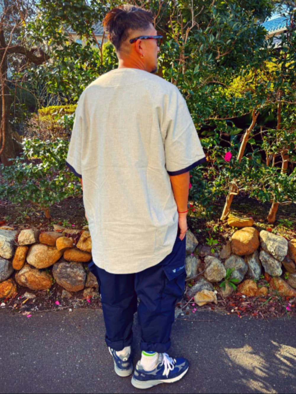 グレー系のTシャツ/カットソー、ブルー系のカーゴパンツ、ブルー系のスニーカーを着用したメンズの秋コーディネートの4枚目の写真