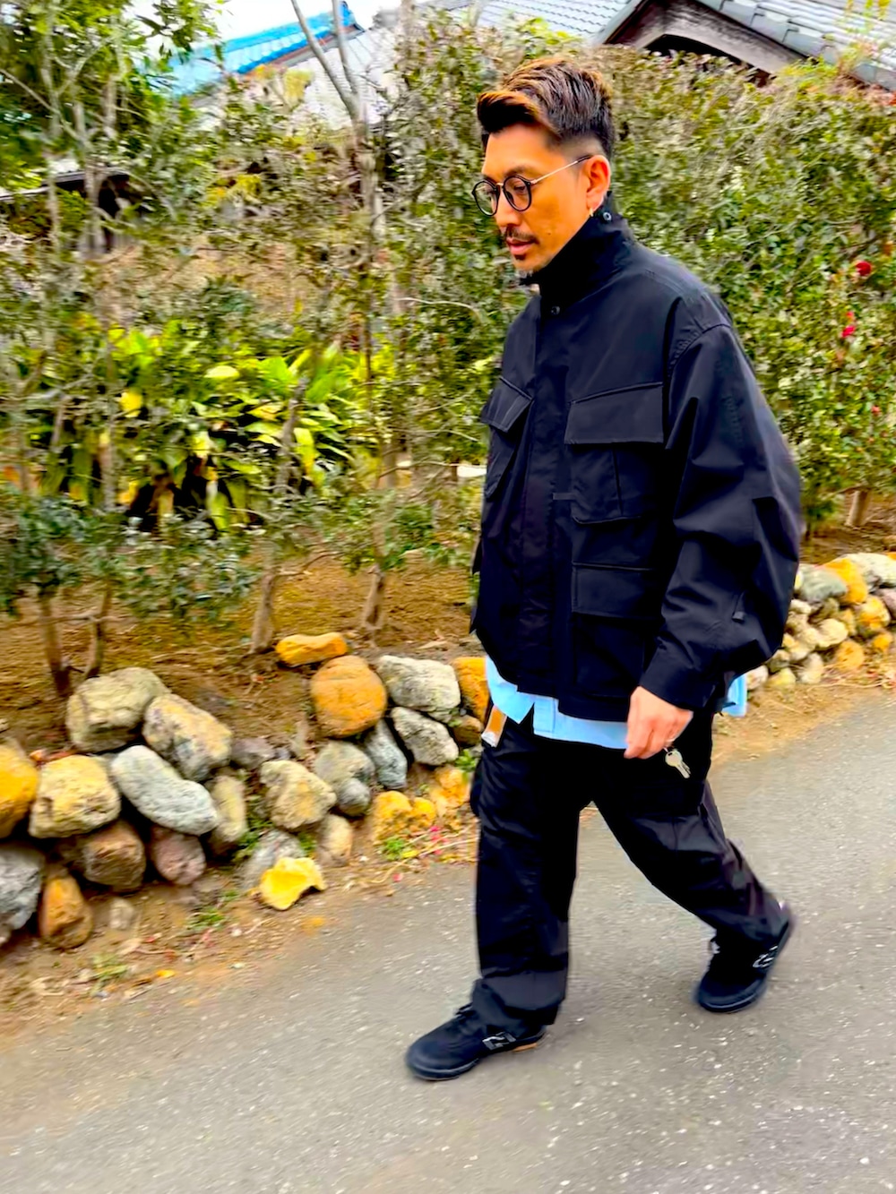 ブラック系のミリタリージャケット、ブルー系のシャツ/ブラウス、ブラック系のカーゴパンツを着用したメンズの冬コーディネートの3枚目の写真