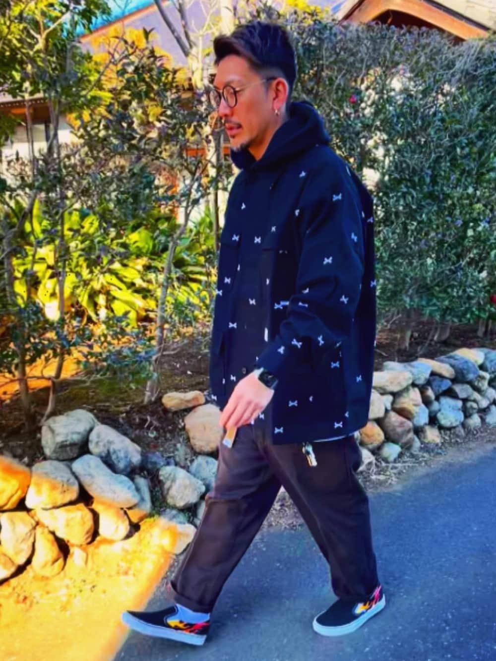 ブラック系のジャケット/アウター、ブラック系のパーカー、レッド系のチノパンツを着用したメンズの冬コーディネートの5枚目の写真