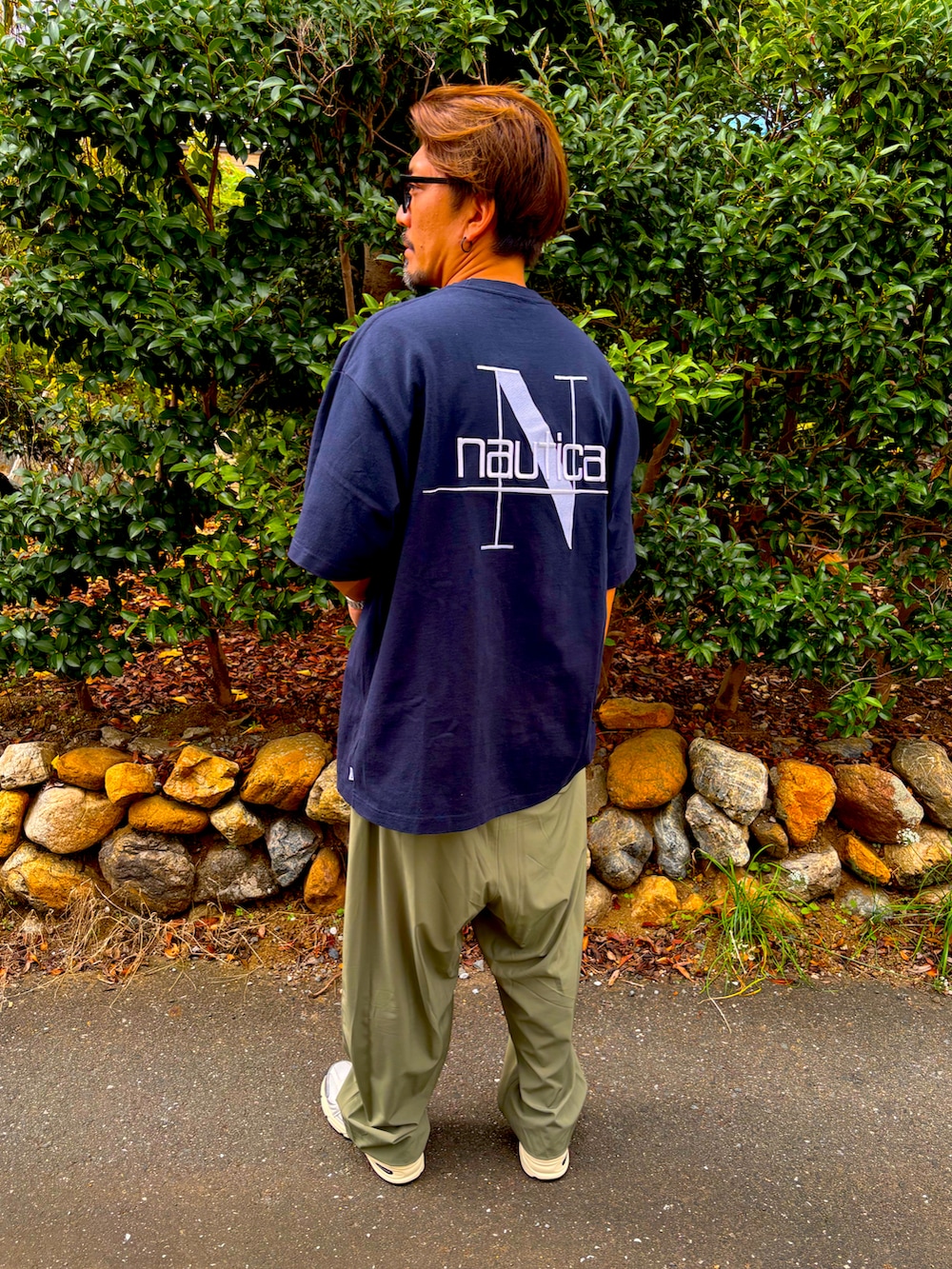 ブルー系のTシャツ/カットソー、グリーン系のその他パンツ、ブラック系のスニーカーを着用したメンズの秋コーディネートの3枚目の写真