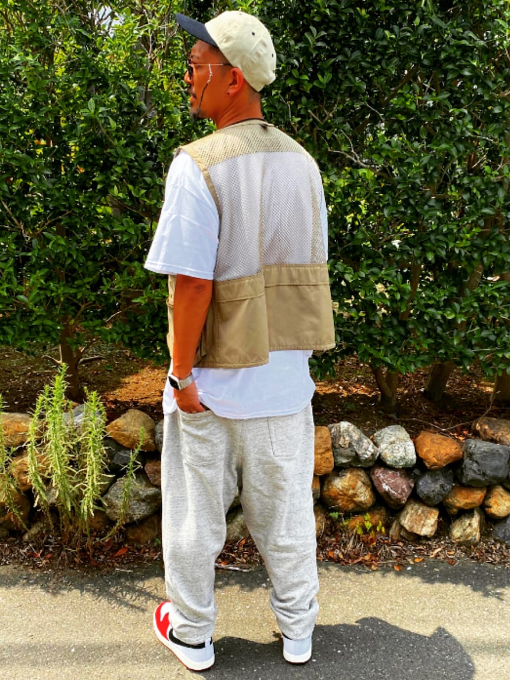 ベージュ系のベスト、ホワイト系のTシャツ/カットソー、シルバー系のスウェットパンツを着用したメンズの春コーディネートの4枚目の写真