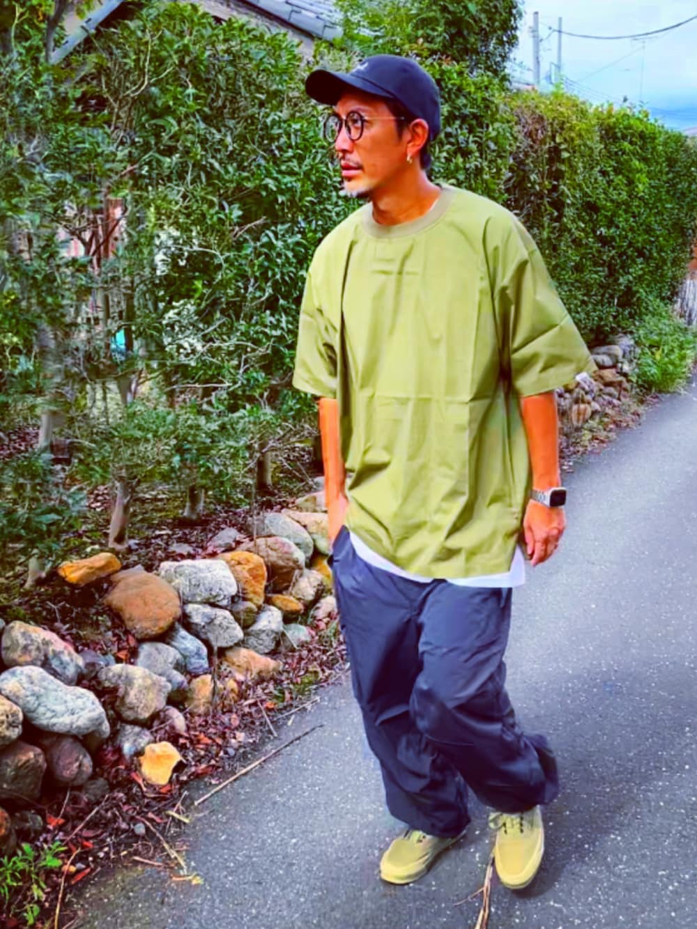 グリーン系のTシャツ/カットソー、ブラック系のその他パンツ、グリーン系のスニーカーを着用したメンズの秋コーディネートの2枚目の写真