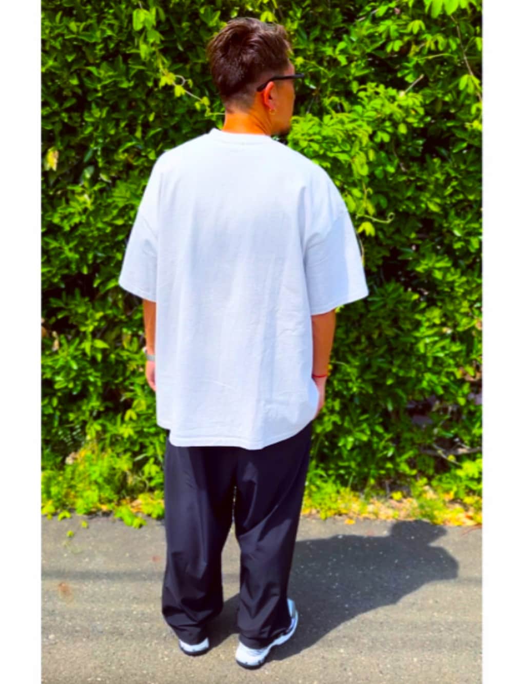 グレー系のTシャツ/カットソー、ブラック系のその他パンツ、ホワイト系のスニーカーを着用したメンズの春コーディネートの4枚目の写真