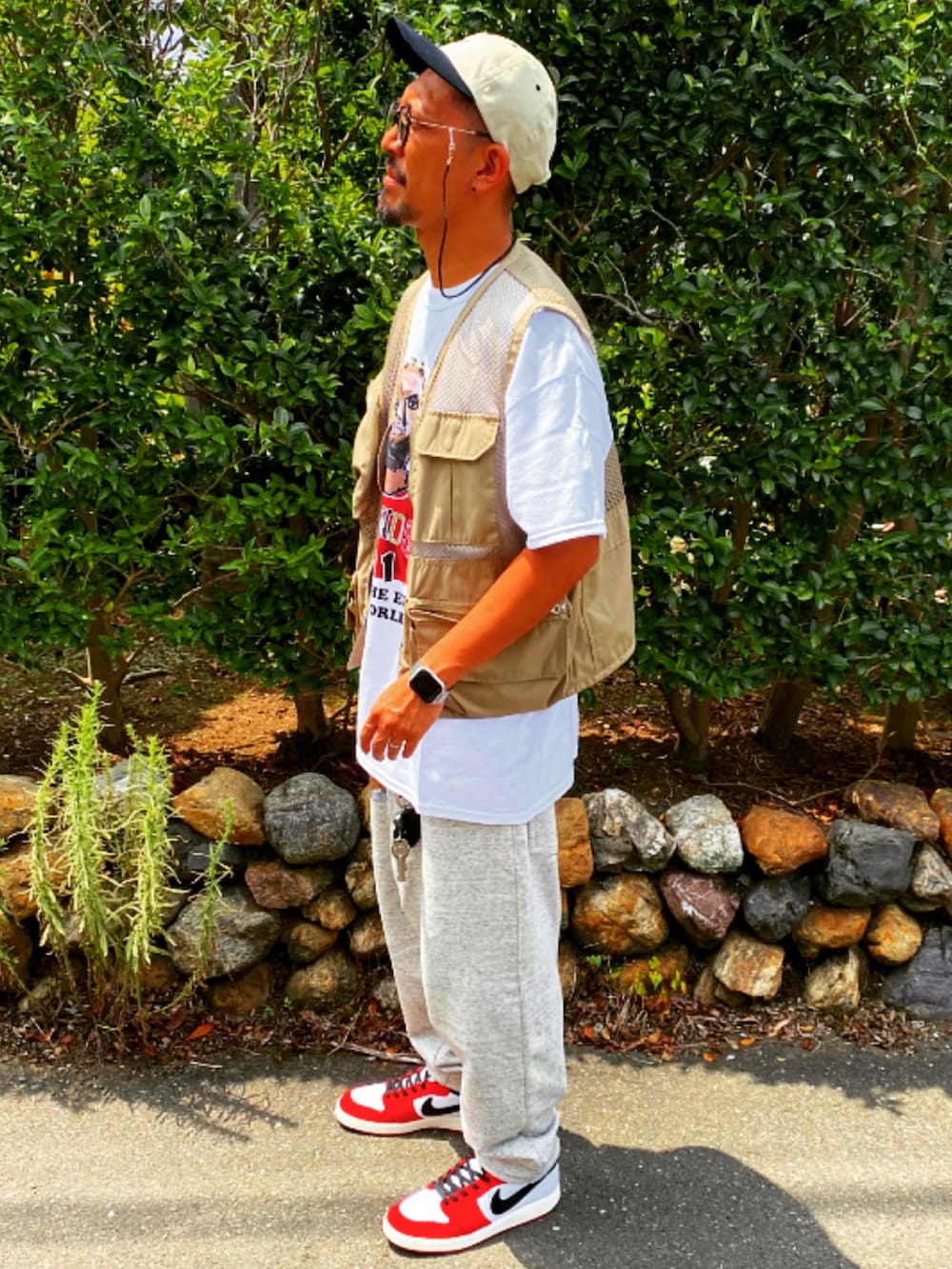 ベージュ系のベスト、ホワイト系のTシャツ/カットソー、シルバー系のスウェットパンツを着用したメンズの春コーディネートの2枚目の写真